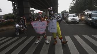 Badut yang tergabung dalam Aku Badut Indonesia (ABI) melakukan kampanye melawan virus Corona di kawasan Pasar Rebo, Jakarta, Sabtu (18/4). [Suara.com/Angga Budhiyanto]