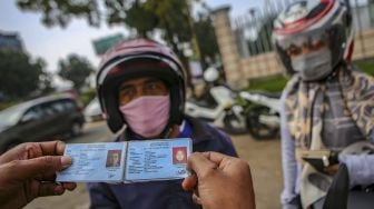 Petugas memeriksa pengendara saat penerapan Pembatasan Sosial Berskala Besar (PSBB) di jalan M.H Thamrin, Cikokol, Kota Tangerang, Banten, Sabtu (18/4). [ANTARA FOTO/Fauzan]