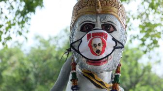 Patung wayang yang dipasangi masker kain di halaman Balai Kota Solo, Jawa Tengah, Minggu (19/4).  [ANTARA FOTO/Maulana Surya]