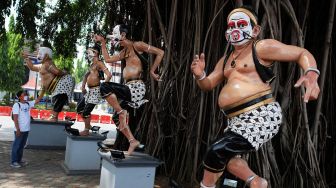 Patung wayang menggunakan masker kain di halaman Balai Kota Solo, Jawa Tengah, Minggu (19/4).  [ANTARA FOTO/Maulana Surya]