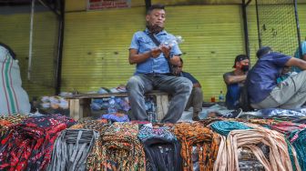 Pedagang menjajakan masker jualannya di Pasar Asemka, Jakarta Barat, Minggu (19/4). [Suara.com/Alfian Winanto]