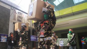 Anggota Banser membawa distribusi Alat Pelindung Diri ( APD) di kantor PP GP Ansor, Jakarta, Senin (20/4).  [Suara.com/Oke Atmaja]
