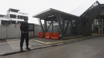 Petugas berjaga di pintu masuk Stasiun MRT Blok A, Jakarta Selatan, Selasa (21/4). [Suara.com/Angga Budhiyanto]