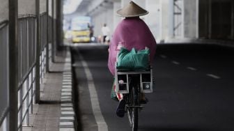 Pedagang membawa barang dagangannya dengan sepeda melintas di kawasan Kebayoran Baru, Jakarta, Selasa (21/4). [Suara.com/Angga Budhiyanto]










