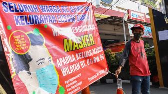 Warga berjaga didepan gerbang karantina wilayah Di Jalan Kramat Pangeran Syarif, Lubang Buaya, Jakarta Timur (22/4). [Suara.com/Alfian Winanto]