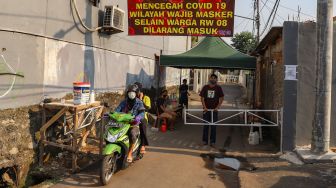 Warga Gang Langgar RW 08 melakukan karantina wilayah atau Lockdown Mandiri di Jalan Monumen Pancasila Sakti, Lubang Buaya, Jakarta Timur (22/4). [Suara.com/Alfian Winanto]
