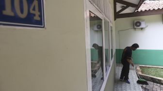 Petugas Badan Layanan Umum Daerah (BLUD) menyapu salah satu kamar yang akan dijadikan tempat tinggal sementara tenaga medis penanganan Corona (Covid-19) di SMK Negeri 57, Jakarta, Kamis (23/4). [Suara.com/Angga Budhiyanto]