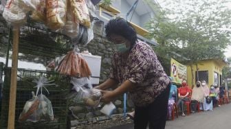 Warga memilih  sayur untuk dibeli dengan menjaga jarak di Perumahan Taman Anyelir 3, Cilodong, Depok, Jawa Barat, Selasa (28/4). [Suara.com/Angga Budhiyanto]