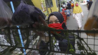 Warga membeli sayur dengan menjaga jarak di Perumahan Taman Anyelir 3, Cilodong, Depok, Jawa Barat, Selasa (28/4). [Suara.com/Angga Budhiyanto]