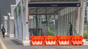 Petugas keamanan berjaga didepan pintu masuk stasiun MRT Senayan, Jakarta Pusat, Rabu (29/4). [Suara.com/Alfian Winanto]