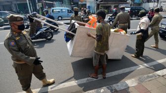 Sejumlah petugas Satpol PP menangkap pengemis di Jalan Dewi Sartika, Cawang, Jakarta, Rabu (29/4). [ANTARA FOTO/Aditya Pradana Putra]