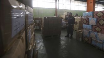 Petugas berjaga di gudang Perumda Pasar Jaya, Pulogadung, Jakarta Timur, Kamis (30/4).   [Suara.com/Angga Budhiyanto]