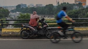 Perempuan ngabuburit di Flyover Pasar Rebo, Jakarta Timur, Kamis (30/4). [Suara.com/Alfian Winanto]