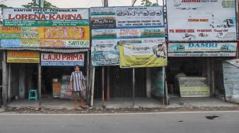 Kondisi beberapa gerai agen bus yang tetap buka semenjak diberlakukannya larangan mudik di Jalan Raya Bogor, Cimanggis, Depok, Jumat (1/5). [Suara.com/Alfian Winanto]