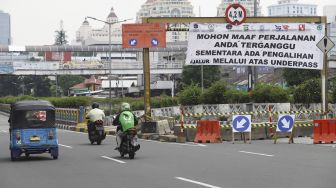 Kendaraan melintas di samping underpass Senen yang ditutup di Jakarta, Jumat (1/5).  [Suara.com/Angga Budhiyanto]