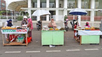 Aktivitas para pedagang takjil di Jalan Panjang, Kebon Jeruk, Jakarta barat, Jumat (1/5). [Suara.com/Alfian Winanto]
