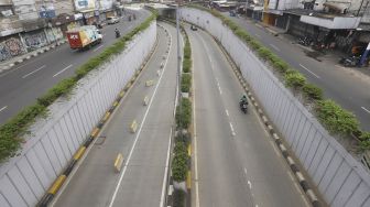 Kendaraan melintas di samping underpass Senen yang ditutup di Jakarta, Jumat (1/5).  [Suara.com/Angga Budhiyanto]