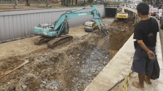 Pekerja dengan alat berat menyelesaikan proyek pembangunan Underpass Senen Extension di Jakarta, Jumat (1/5). [Suara.com/Angga Budhiyanto]