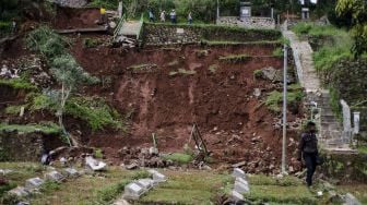 Petugas membersihkan sejumlah makam yang rusak terdampak longsor di TPU Cikutra, Bandung, Jawa Barat, Sabtu (2/5). [ANTARA FOTO/Novrian Arbi]