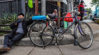 Pengojek sepeda ontel mangkal menunggu penumpang di kawasan Kota Tua, Jakarta Barat, Minggu (3/5). [Suara.com/Alfian Winanto]