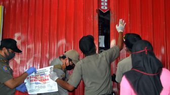 Satpol PP menyegel toko busana yang melanggar aturan Pembatasan Sosial Berskala Besar (PSBB) di Kota Bogor, Jawa Barat, Senin (4/5). [ANTARA FOTO/Arif Firmansyah]