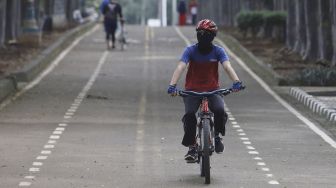 Warga berolahraga di kawasan Banjir Kanal Timur (BKT), Jakarta, Senin (4/5). [Suara.com/Angga Budhiyanto]