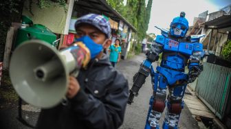 Petugas keamanan yang tergabung dalam Satuan Tugas Anti Nongkrong mengenakan kostum robot saat berpatroli keliling kampung di Sekepanjang, Bandung, Jawa Barat, Senin (4/5). . [ANTARA FOTO/Raisan Al Farisi]