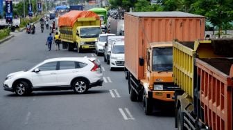 Sebuah mobil berusaha putar balik keluar dari antrean kendaraan yang akan melewati titik pemeriksaan di perbatasan Kabupaten Gowa dan Makassar, Sulawesi Selatan, Senin (4/5). [ANTARA FOTO/Abriawan Abhe]