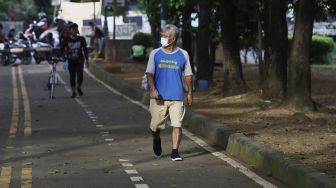 Warga berolahraga di kawasan Banjir Kanal Timur (BKT), Jakarta, Senin (4/5). [Suara.com/Angga Budhiyanto]