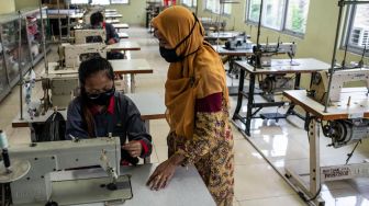 Pekerja korban PHK terdampak COVID-19 Elma Meika (20) (kiri) menyimak arahan instruktur saat mengikuti pelatihan menjahit di Balai Mulya Jaya, Jakarta, Kamis (7/5).  [ANTARA FOTO/Aprillio Akbar]