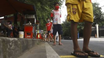 Warga mengantre dengan menerapkan aturan jarak fisik atau 'physical distancing' untuk mendapatkan takjil gratis di Jalan Cempaka Putih Tengah, Kecamatan Cempaka Putih, Jakarta Pusat, Kamis (7/5). [Suara.com/Angga Budhiyanto]