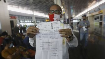 Seorang calon penumpang dengan ijin khusus perjalanan dinas menunjukan surat syarat terbang di Terminal 3 Bandara Soekarno Hatta, Tangerang, Banten, Kamis (7/5). [Suara.com/Angga Budhiyanto]