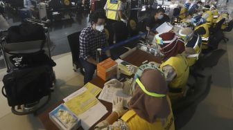 Petugas medis dari Kantor Kesehatan Pelabuhan (KKP) Kelas 1 Soekarno Hatta melakukan pengecekan kesehatan calon penumpang sebelum melakukan penerbangan di Terminal 3 Bandara Soekarno Hatta, Tangerang, Banten, Kamis (7/5). . [Suara.com/Angga Budhiyanto]
