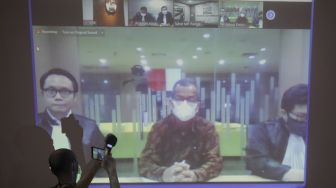 Tayangan video conference (vicon) yang menayangkan terdakwa mantan Dirut Garuda Indonesia Emirsyah Satar (tengah) menjalani sidang pembacaan putusan di gedung KPK, Jakarta, Jumat (8/5). [ANTARA FOTO/Reno Esnir]