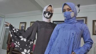 Model menunjukkan busana muslim bermotif jumputan yang senada dengan masker rancangan desainer asal Sumatera Selatan Tria Gunawan di Rumah Busana Tria Palembang, Sumsel, Kamis (7/5). [ANTARA FOTO/Feny Selly]