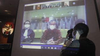 Tayangan video conference (vicon) yang menayangkan terdakwa mantan Dirut Garuda Indonesia Emirsyah Satar (kedua kiri) menjalani sidang pembacaan putusan di gedung KPK, Jakarta, Jumat (8/5). [ANTARA FOTO/Reno Esnir]