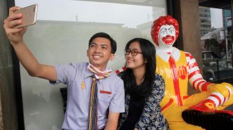 Pengunjung berselfie berlatarkan patung badut Mcdonalds Sarinah Thamrin, Jakarta, Jumat (8/5). [Suara.com/Oke Atmaja]

