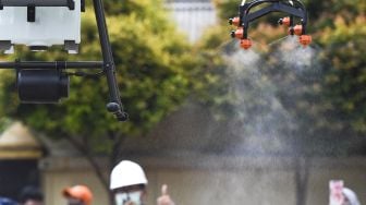 Sebuah pesawat nirawak atau drone menyemprotkan cairan disinfektan di kawasan Pancoran, Jakarta, Senin (11/5).  [ANTARA FOTO/Hafidz Mubarak ]
