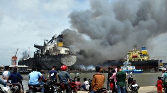 Sejumlah warga melihat terbakarnya kapal tanker MT JAG LEELA di Pelabuhan Belawan Medan, Sumatera Utara, Senin (11/5).  [ANTARA FOTO/Septianda Perdana]