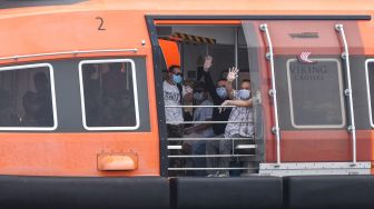 Warga Negara Indonesia (WNI) yang menjadi Anak Buah Kapal (ABK) Kapal Pesiar MV Viking Orion melambaikan tangan saat tiba di Pelabuhan JICT, Tanjung Priok, Jakarta, Senin (11/5).  [ANTARA FOTO/M Risyal Hidayat]