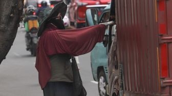 Pengendara truk menukar pecahan uang baru di kawasan Kota Tua, Jakarta Barat, Kamis (14/5). [Suara.com/Alfian Winanto]
