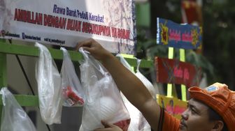 Petugas menata sembako yang digantung di rak kayu di kawasan Rawa Barat, Jakarta Selatan, Kamis (14/5). [Suara.com/Angga Budhiyanto]