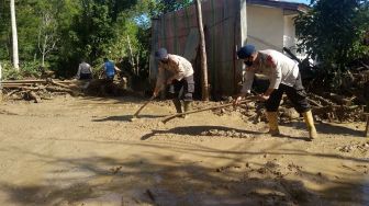 Personil Polres Aceh Tengah membantu warga membersihkan material kayu dan lumpur akibat banjir bandang di Desa Paya Tumpi Baru, Kecamatan Kebayakan, Aceh Tengah, Aceh, Kamis (14/5). [ANTARA FOTO/Kurnia Muhadi]