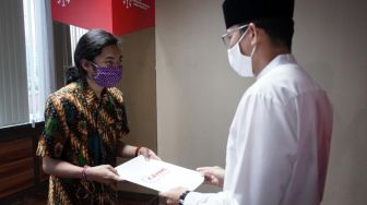 Tokoh inspirator entrepreneur Nasional Sandiaga Uno (kanan) menyerahkan beasiswa KAHMIPreneur Ke sejumlah Pelajar dan Mahasiswa Berjiwa wirausaha di Jakarta, Kamis (14/05).  [Suara.com/OkeAtmaja]