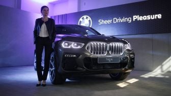 Model berpose disamping mobil "The New BMW X6" saat peluncurannya yang dilakukan secara virtual di Serpong, Tangerang Selatan, Banten, Jumat (15/5).  [ANTARA FOTO/Muhammad Iqbal]