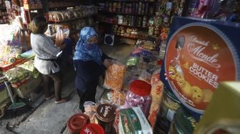 Calon pembeli memilih kue kering dalam kemasan di kawasan Ciracas, Jakarta, Sabtu (16/5).  [Suara.com/Angga Budhiyanto]