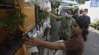 Warga mengambil paket sembako gratis di kawasan Jati Padang, Jakarta, Minggu (17/5). [Suara.com/Angga Budhiyanto]