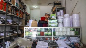 Pedagang menunggu pembeli datang mencari Peci di Condet, Jakarta Timur (19/5). [Suara.com/Alfian Winanto]