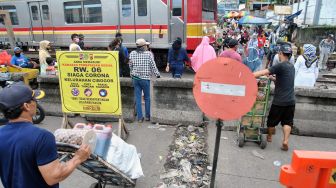 Warga menunggu KRL Commuter Line lewat di perlintasan Pasar Anyar yang ditutup beton di Kota Bogor, Jawa Barat, Selasa (19/5).  [ANTARA FOTO/Arif Firmansyah]
