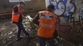 Warga yang terjaring razia penindakan pelanggaran aturan Pembatasan Sosial Berskala Besar (PSBB) oleh Tim Satgas Gugus Tugas COVID-19 menjalani hukuman dengan cara membersihkan sampah di kawasan Cilandak, Jakarta, Selasa (19/5). [Suara.com/Angga Budhiyanto]